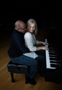 Anne and Dave sitting together at the piano